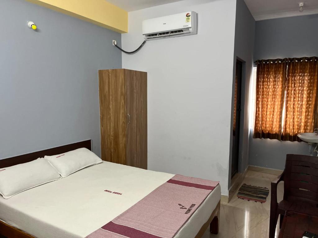 a bedroom with a bed and a air conditioner at Velan view in Palni