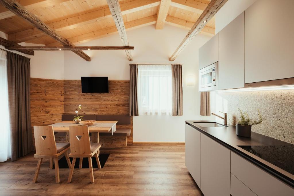 a kitchen and dining room with a table and chairs at Chalet La Flüta Viola in La Valle