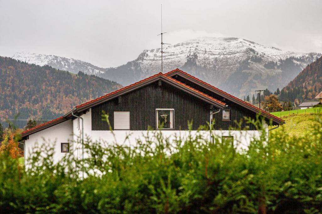 Ein weiß-schwarzes Haus vor dem Hintergrund der Berge in der Unterkunft Q-stadl in Steibis