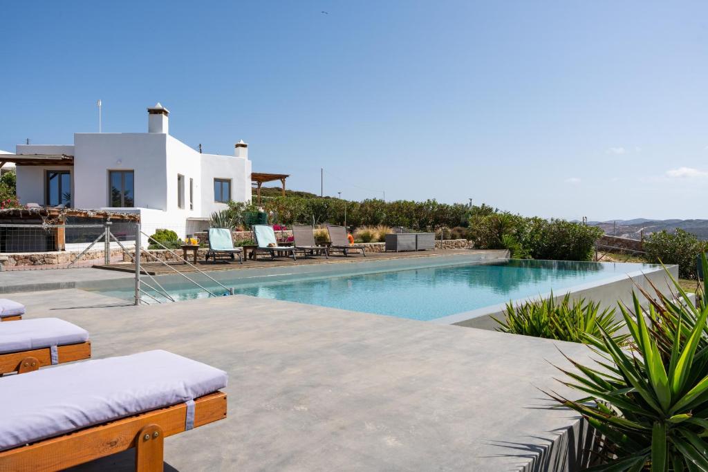 a villa with a swimming pool and a house at Luna Rossa Milos - Moon Kiss in Provatas