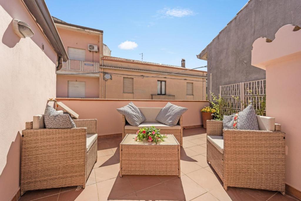 a patio with wicker chairs and tables on a balcony at Su Niu de Arbus in Arbus