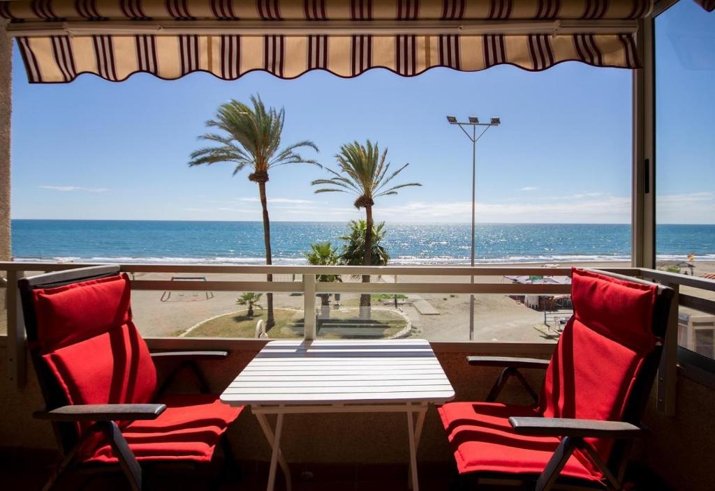 a table and chairs with a view of the ocean at Studio 2 Sea front in Rincón de la Victoria