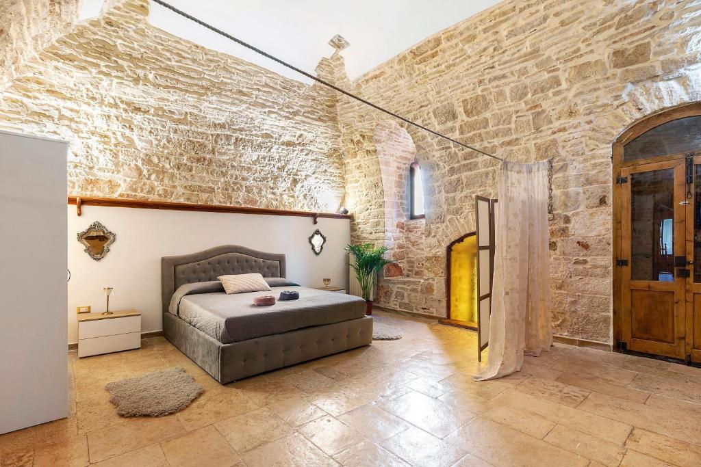 a bedroom with a bed and a brick wall at Apulia Luxury House in Toritto