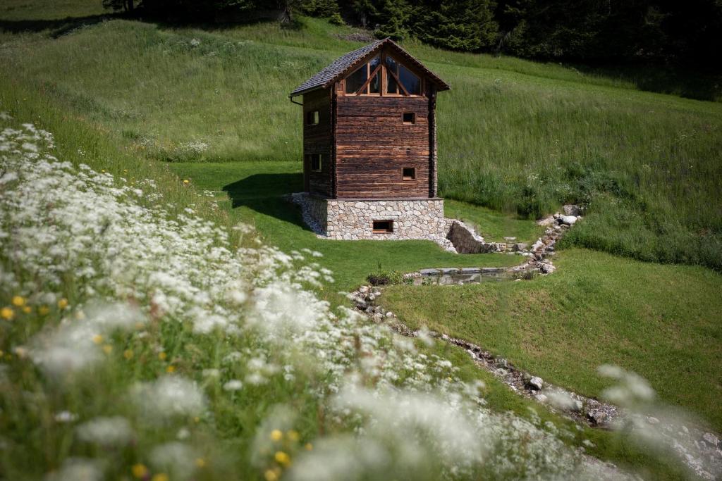 a small building in the middle of a field of flowers at Burgfrieder Mühle in Rasun di Sopra