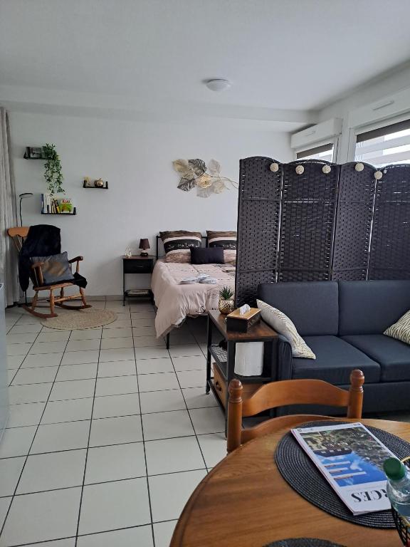 a living room with a couch and a bed at Meublé 3 étoiles en centre-ville in Niederbronn-les-Bains
