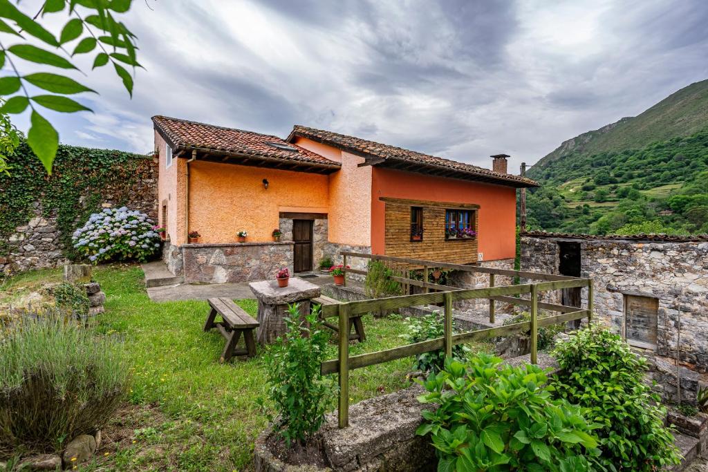 a house on a hill with a bench in front of it at Casa Rural Ricao in Cangas de Onís