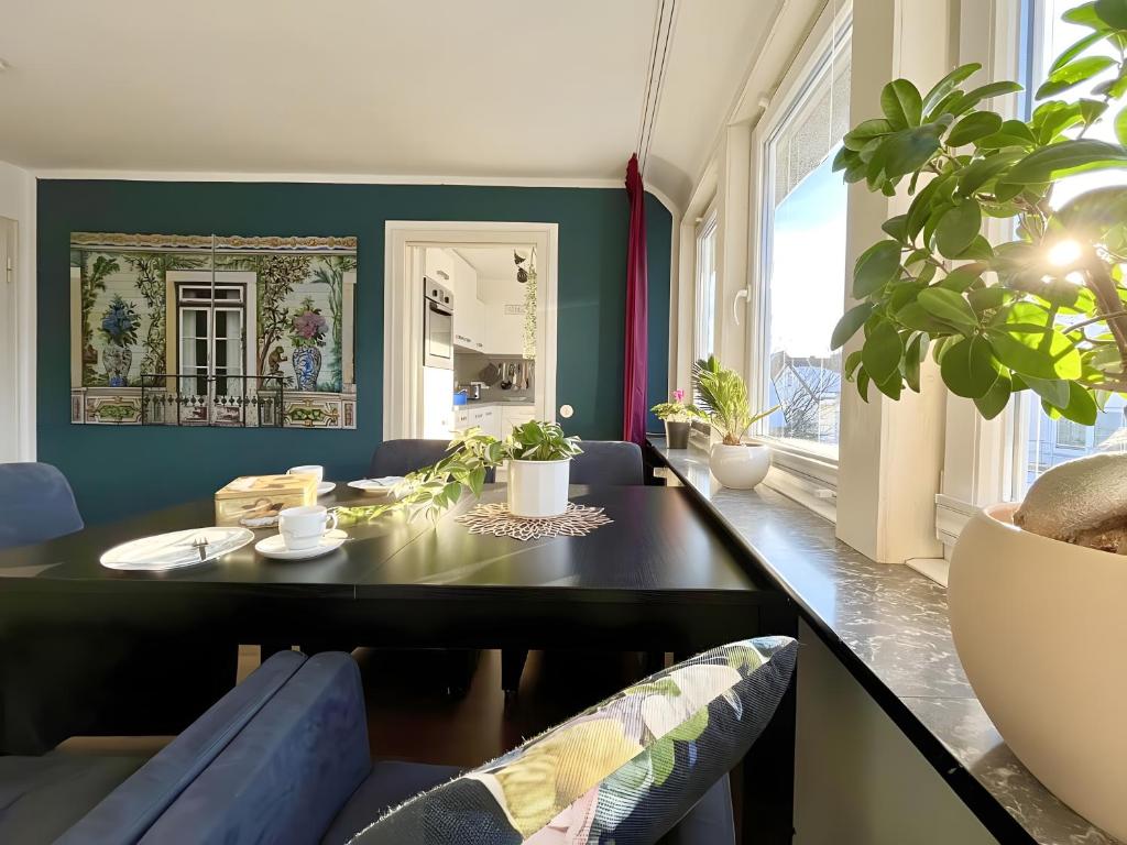 a dining room with a black table and blue walls at Ferienwohnung Ate´s kleine Welt in Brilon