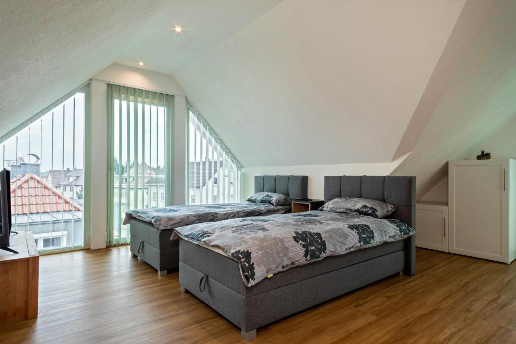 a bedroom with two beds and a large window at Ferienwohnung Alpenblick in Friedrichshafen