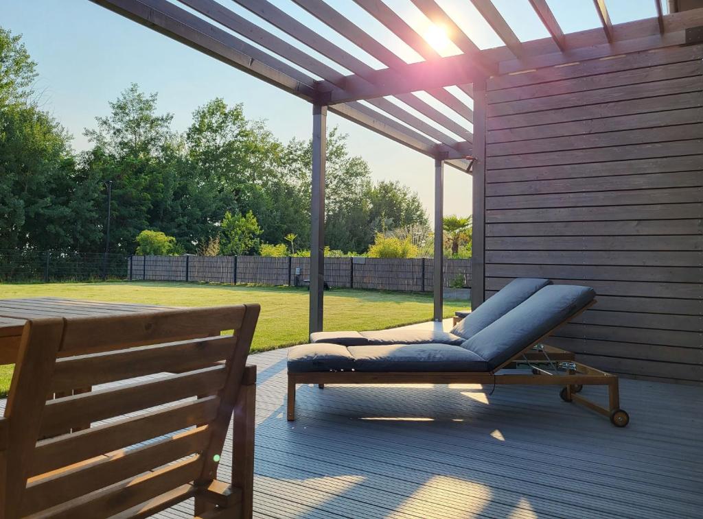 a blue reclining chair under a pergola on a deck at Ferienhaus Schlossterrassen 4a in Pouch