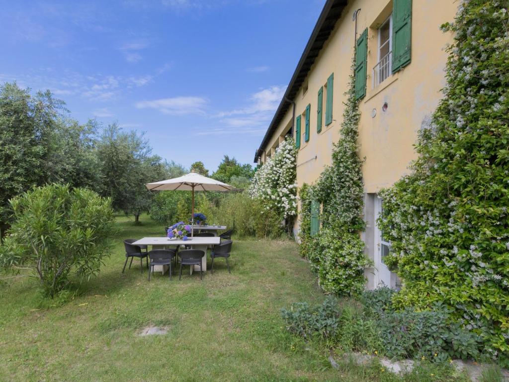 a table with an umbrella next to a building at Delicious House Michelangelo in Cavaion Veronese