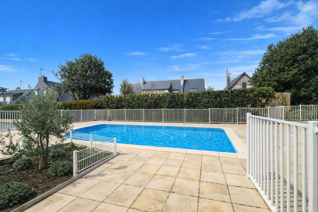 a swimming pool in a yard with a fence at Appartement Ty Avel in Quiberon