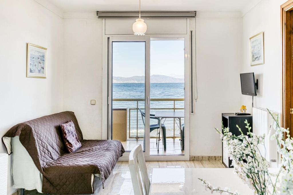 a living room with a couch and a view of the ocean at Platja Mar 3º in L'Escala