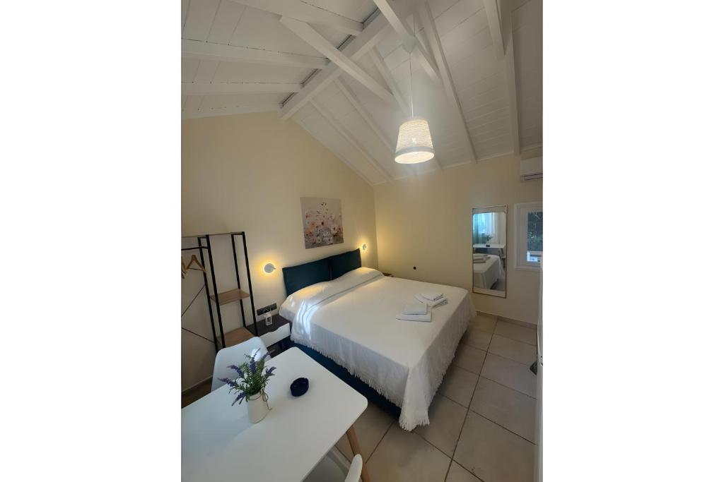 a bedroom with a white bed and a table at Studio Episkopos in Nikiana