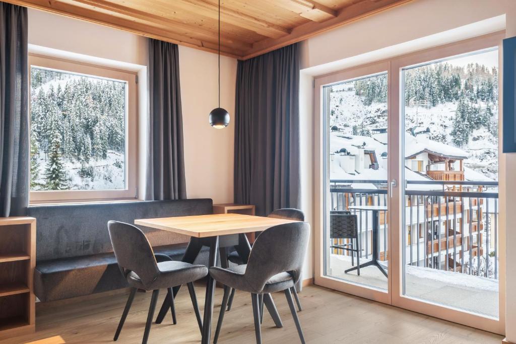 a dining room with a table and chairs and a balcony at La Grambla App Mont Seuc 1 in Santa Cristina Gherdëina
