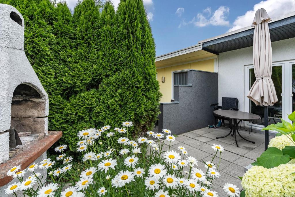 a garden with flowers and a table and an umbrella at Bungalow 73 in Zadelsdorf