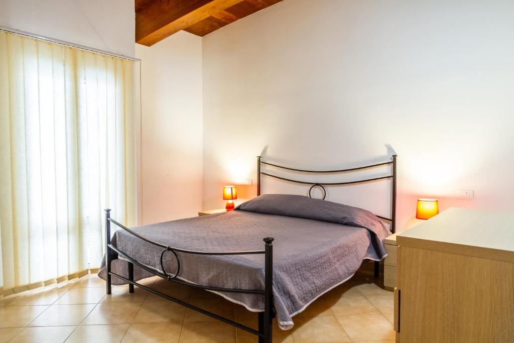a bedroom with a bed with two lamps on it at Aria in Follonica
