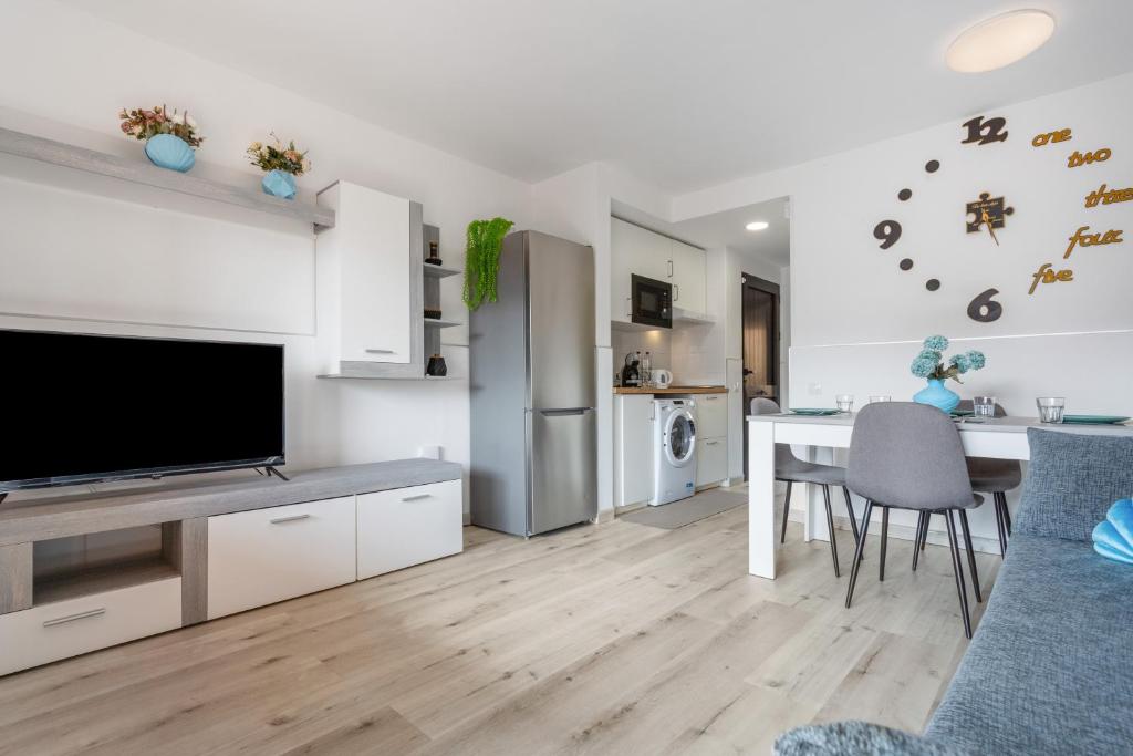 a kitchen and living room with a television and a table at Horizon blu in Corralejo