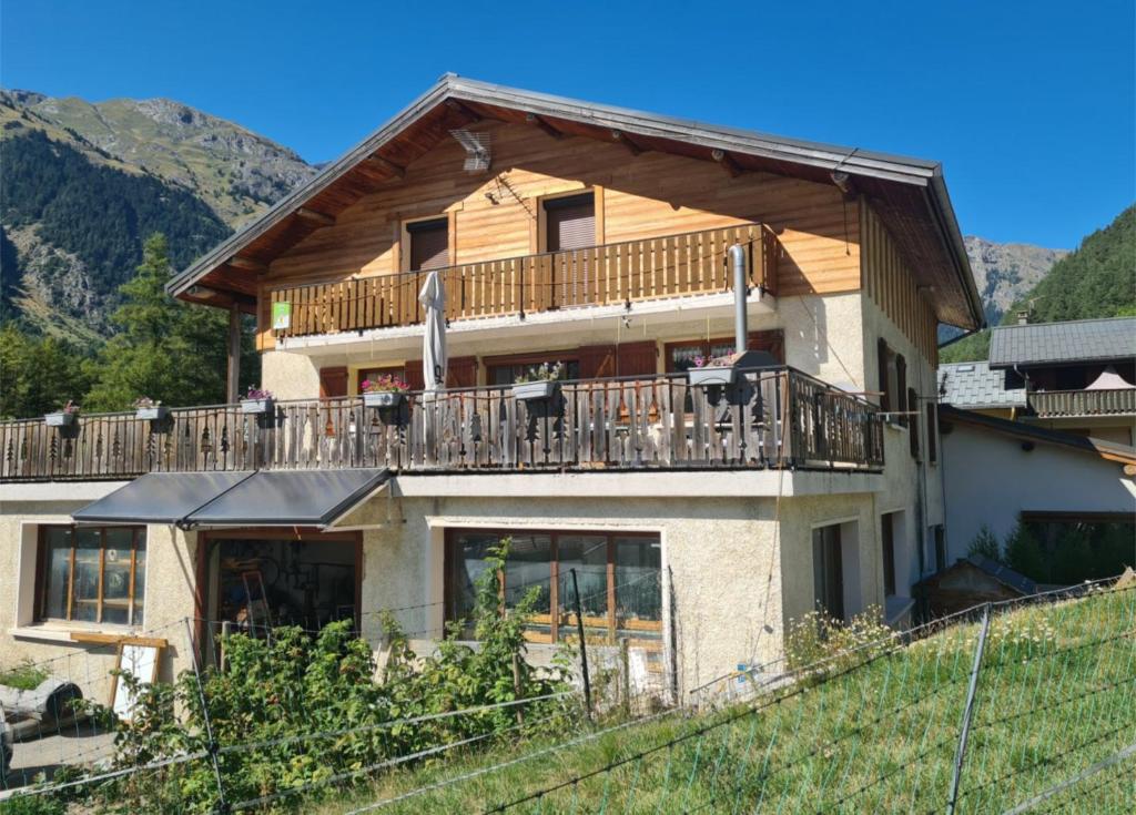 a house with a balcony on top of a hill at Gîte Le Cembro 6 personnes in Termignon