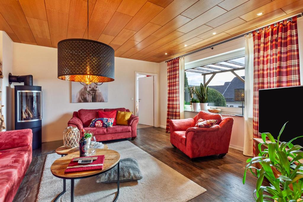 a living room with two red couches and a table at Haus Frigger in Olsberg