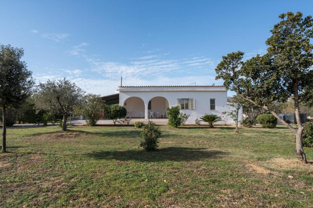 a white house with a yard in front of it at Villa Sa Mela 28 in Orosei