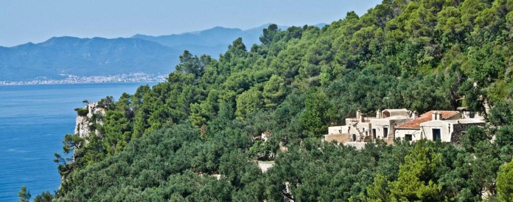 a house on top of a hill next to the water at Agriturismo Bricco in Finale Ligure