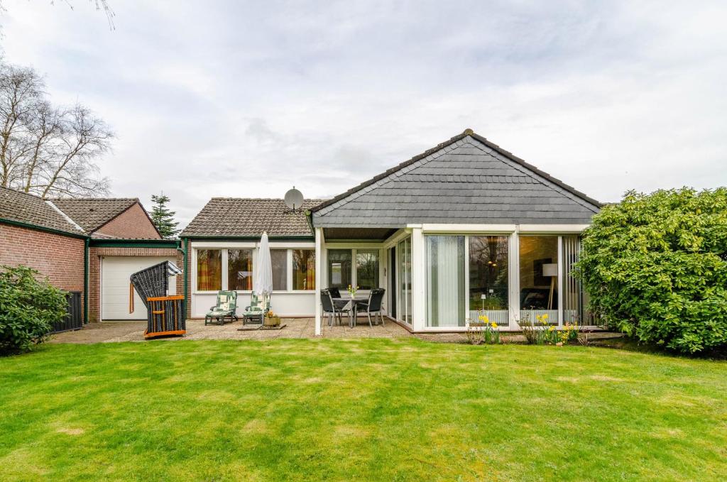 a home with a patio and a yard at Ferienhaus 'am Gänsepfad' in Hage