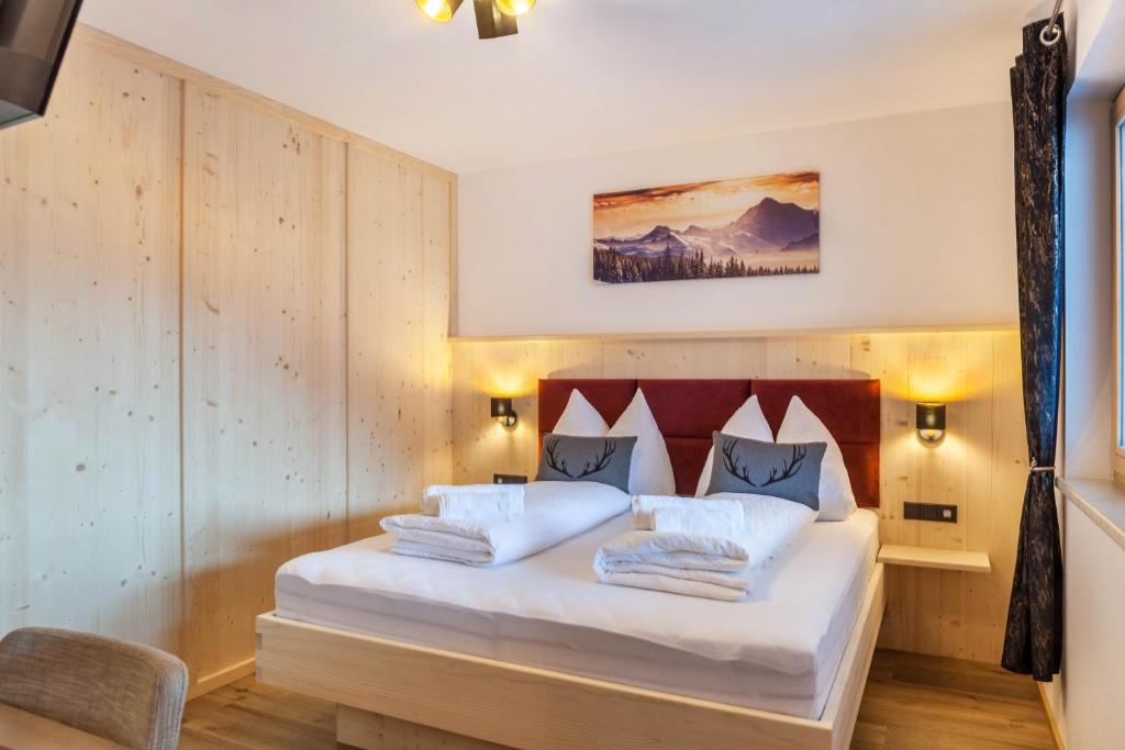a bedroom with a bed with white sheets and pillows at Apartment Bergglück Stummerberg in Stummerberg