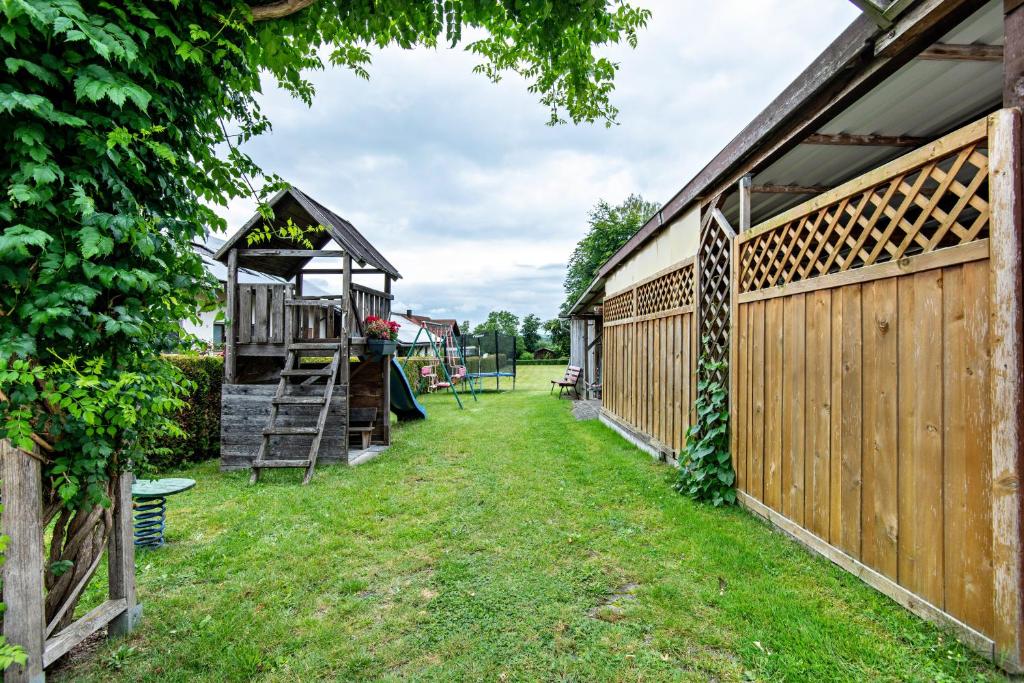 a backyard with a wooden fence and a playground at Ferienwohnung Gruber in Bodenwöhr