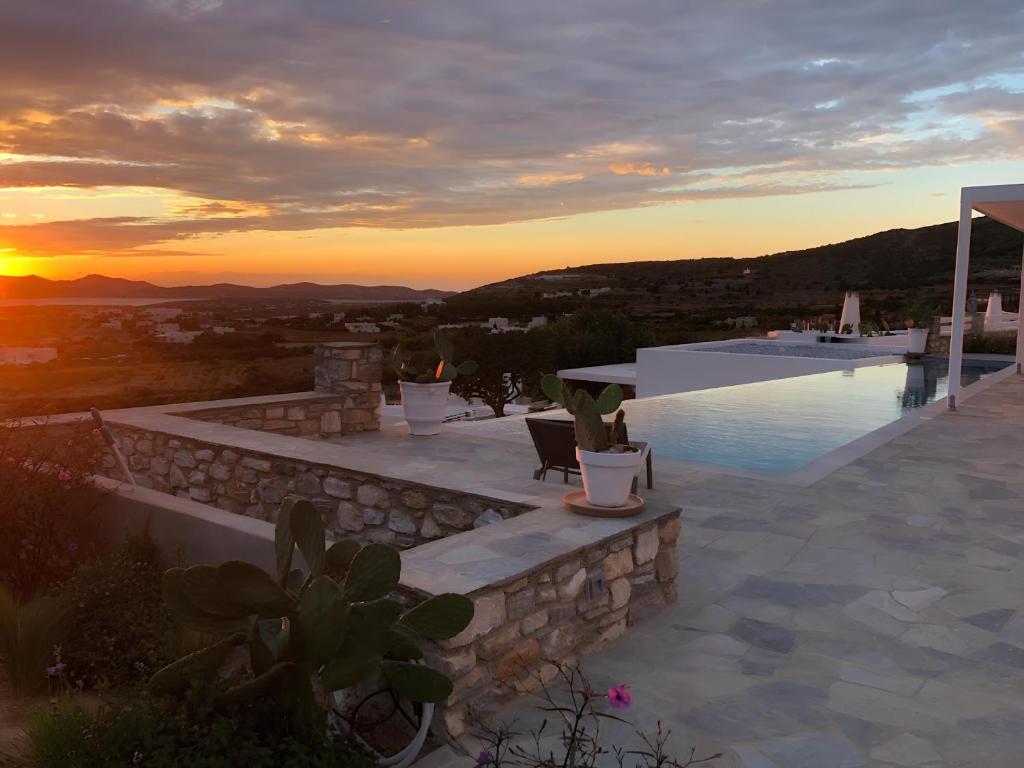 a pool with a sunset in the background at Villa Galazio in Kampos Paros