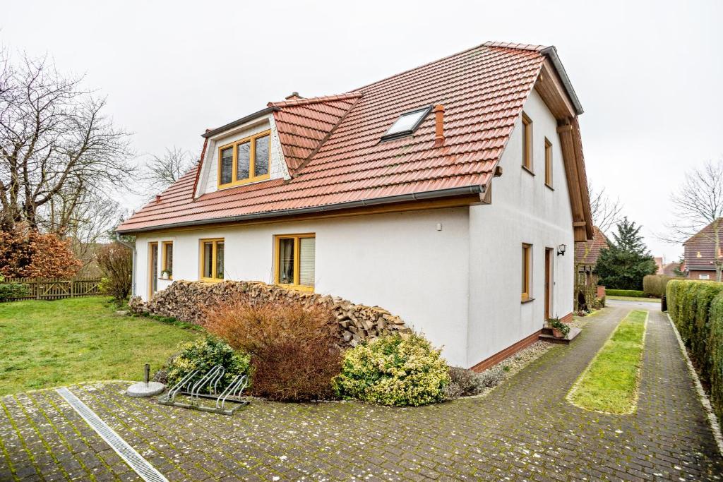 a white house with a red roof at Ferienwohnung 'am Weidenring' in Pantelitz