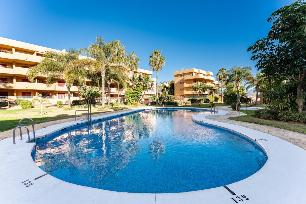 a swimming pool in a resort with palm trees and buildings at 212 La Cala azul in La Cala de Mijas