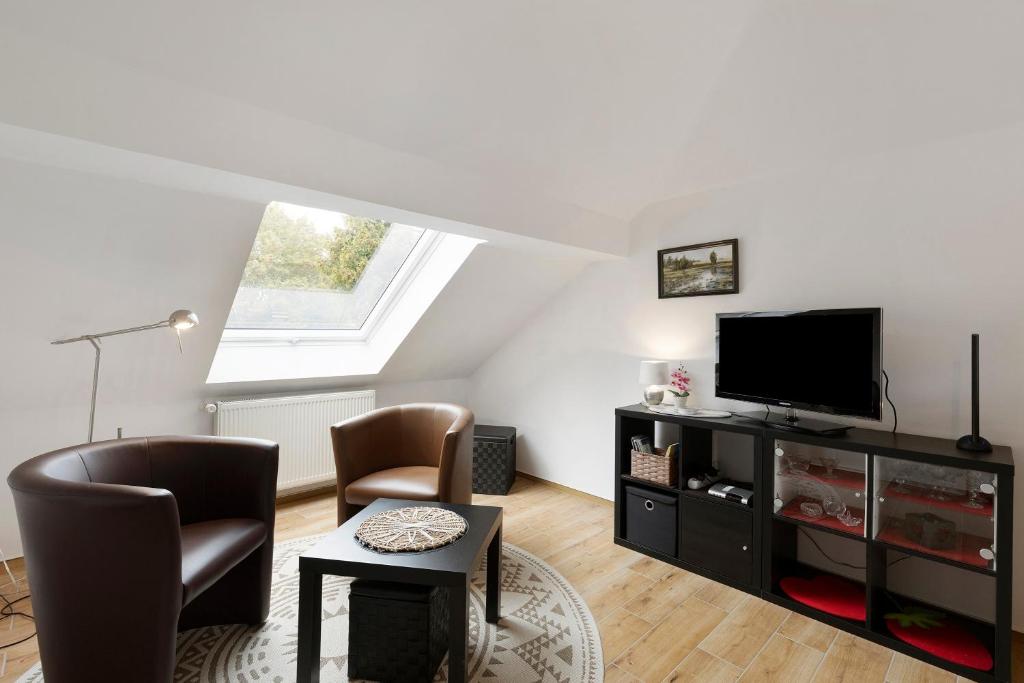 a living room with a flat screen tv and chairs at Ferienwohnung in Potsdam in Potsdam