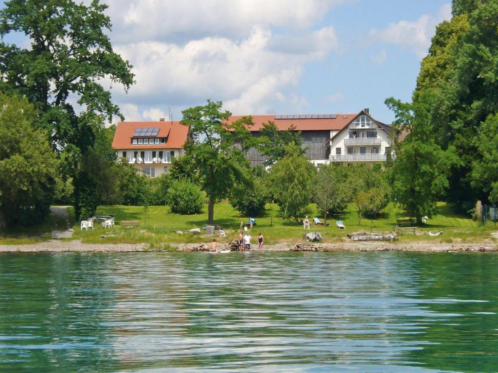 a group of people on the shore of a body of water at Baumanns Ferienhof Am See in Bettnau