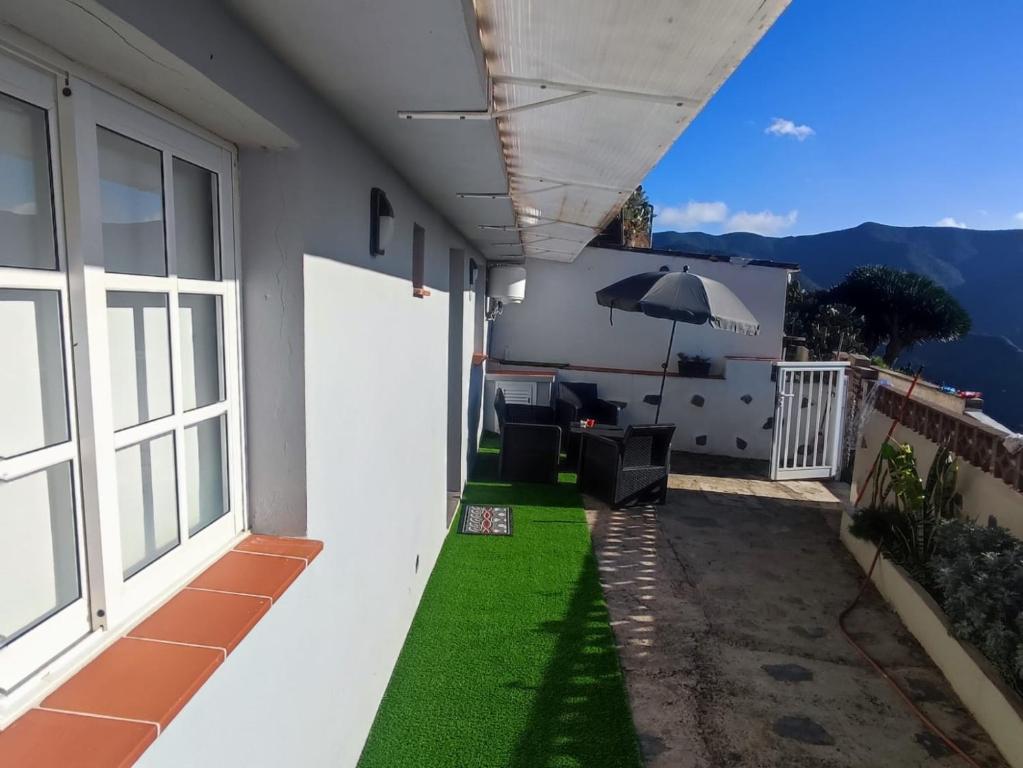 a balcony with green grass and an umbrella at Casa Los Pinos in Chinamada