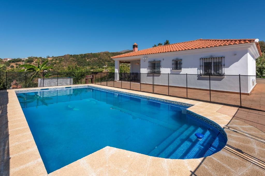a swimming pool in front of a house at Casa con piscina La Madriguera in Estepona