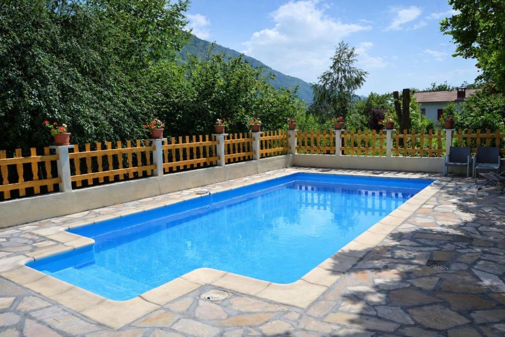 a swimming pool in a backyard with a fence at Chambres d'hôtes - Chez Antho in Betton-Bettonet