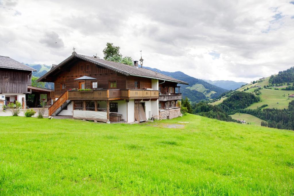a house on a hill with a green field at Appartment Stockeben in Niederau