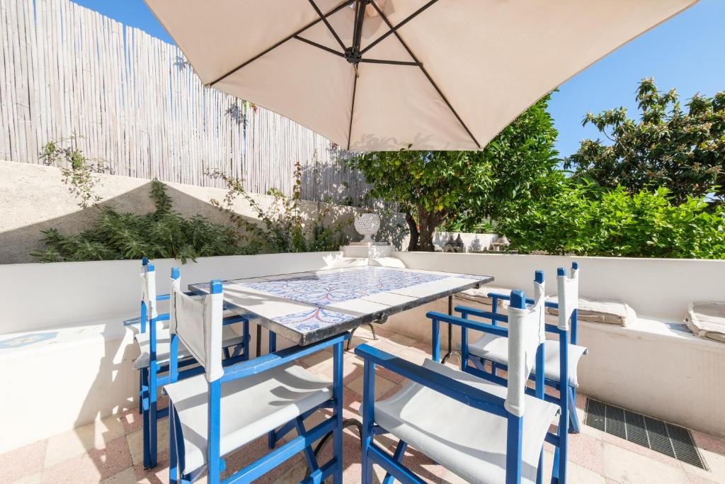 a table and chairs with an umbrella on a patio at La Casa Bianca in Lipari