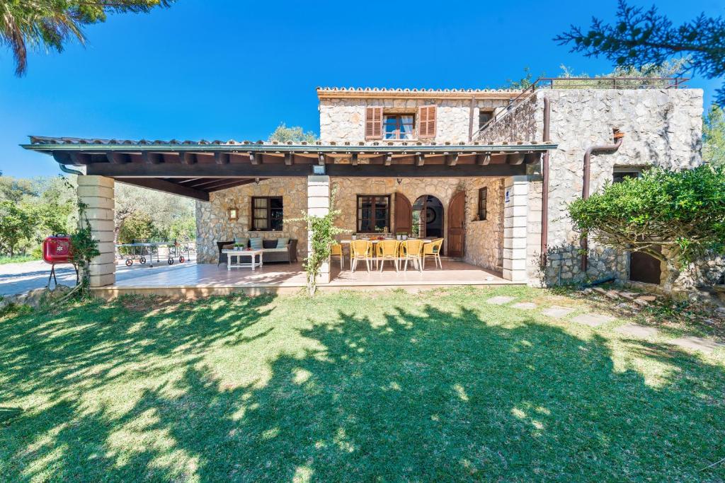 an external view of a stone house with a patio at Can Llobera in Pollença