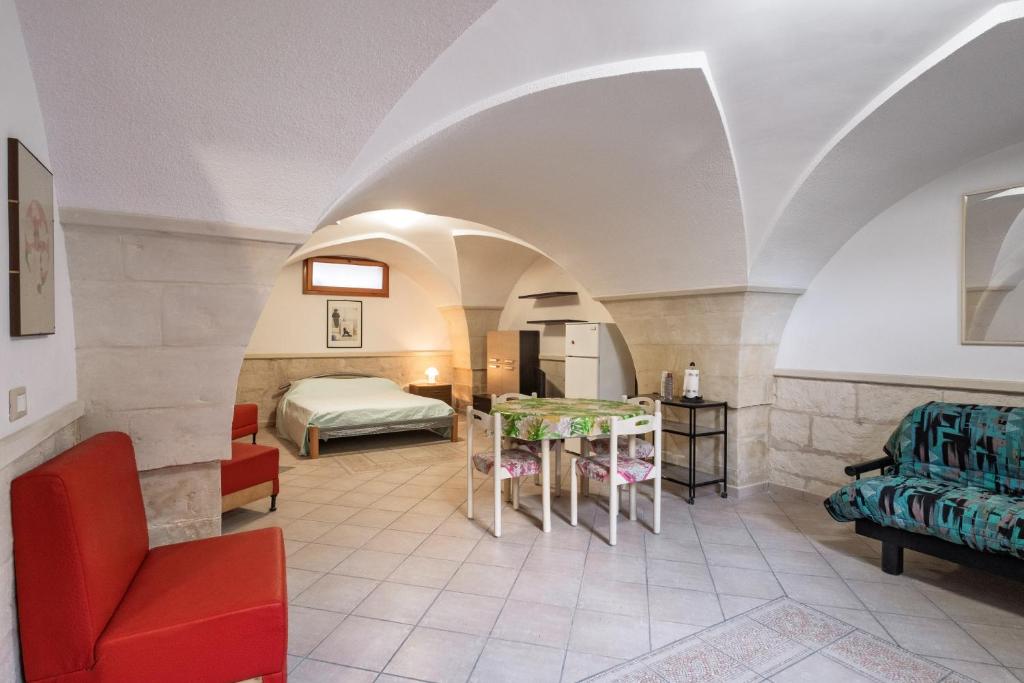 a room with a bed and a table and chairs at Casa dell'Angelo in Muro Leccese