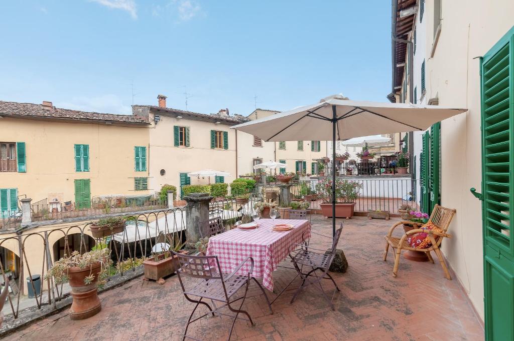 a patio with a table and an umbrella at Il Tuo Posto A Greve In Chianti in Greve in Chianti