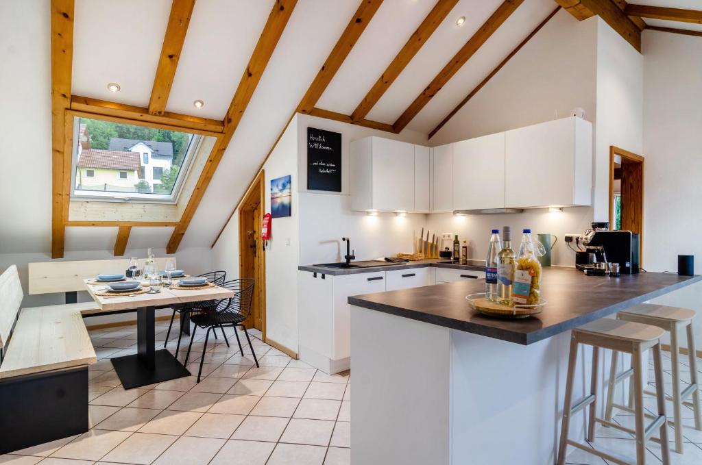 a kitchen with white cabinets and a table and chairs at Enjoy mal - Apartments in Stockach