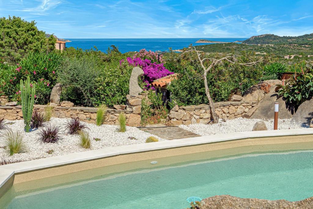 a backyard with a swimming pool and a garden with flowers at Villa Leone con piscina privata in Punta Molara