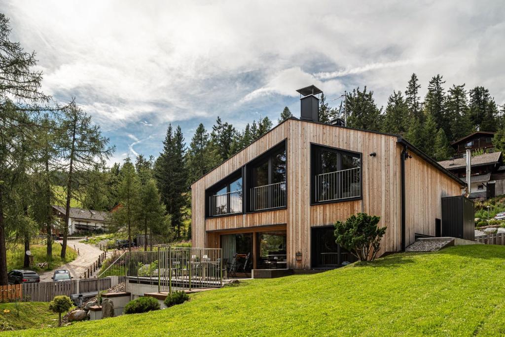 a house on top of a grassy hill at Chalet Bergfreund in Valdaora