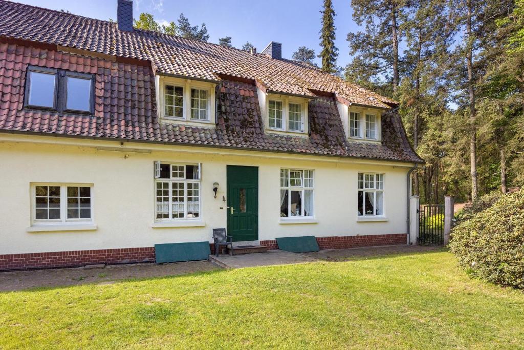 a house with a green door and a yard at Grosszügiges Ferienhaus mit Wald in Gerdau