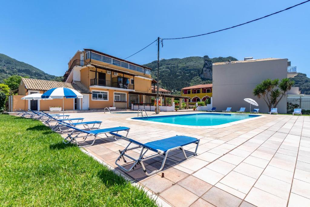 a group of lounge chairs next to a swimming pool at Mires House Side Ground Floor 3 in Agios Gordios