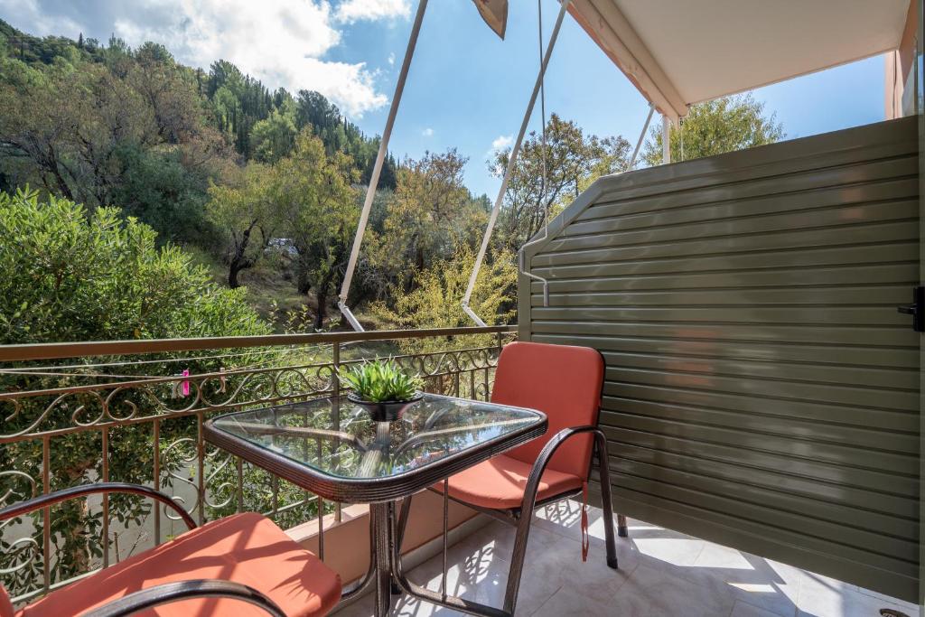 a balcony with a glass table and two chairs at Nontas Home 26 in Kalamitsi