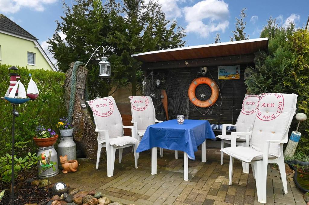 a patio with a table and chairs and a shed at Ferienwohnung Küstenstübchen Gruse in Bartenshagen-Parkentin