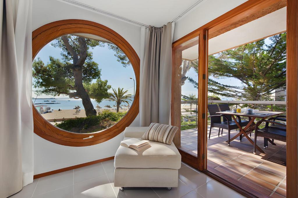 a living room with a large round window and a table at Ull de Bou in Port de Pollensa