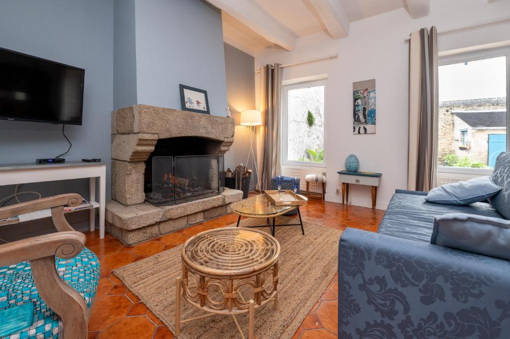 a living room with a couch and a fireplace at Maison Ty Sioul - proche plage in Quiberon